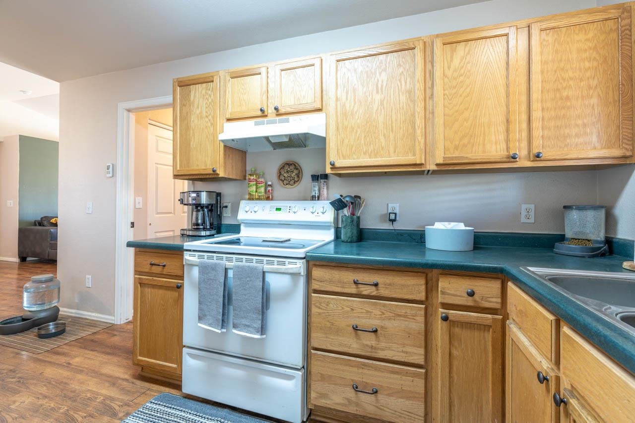 1458 Powell Street Fruita, CO 81521 - Photo 6 of 27 a kitchen with stainless steel appliances white cabinets and a window