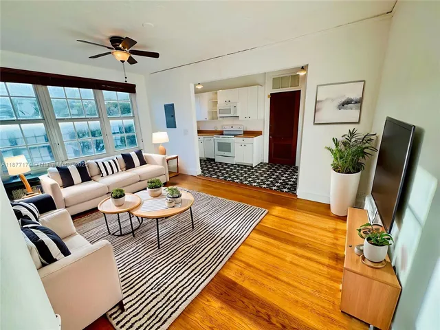 a living room with furniture fireplace and a large window