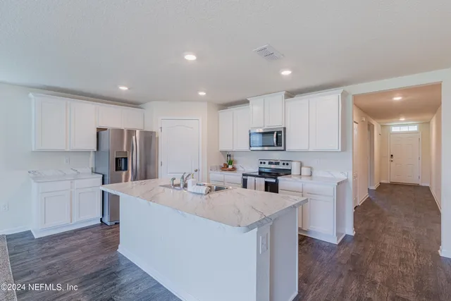 a kitchen with refrigerator and cabinets