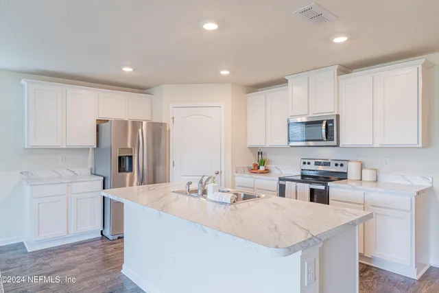 a kitchen with refrigerator and cabinets