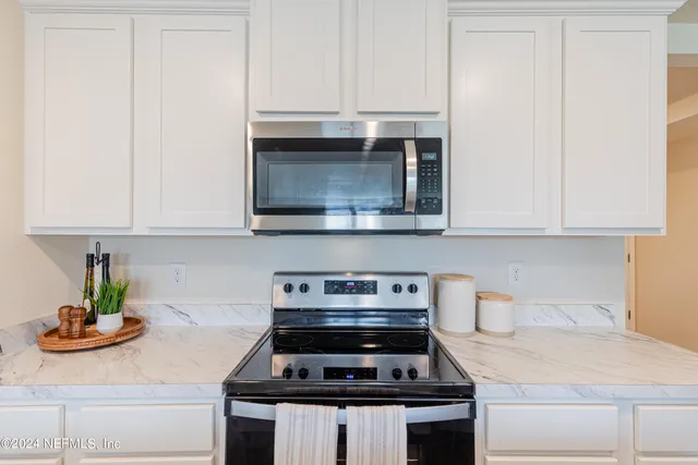 a kitchen with stainless steel appliances kitchen island granite countertop a refrigerator and a stove top oven