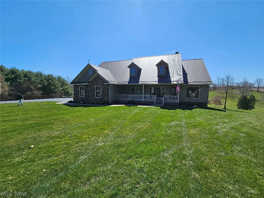 View of front of home featuring covered porch and a front lawn