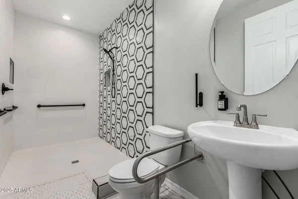 a bathroom with a sink a toilet and shower