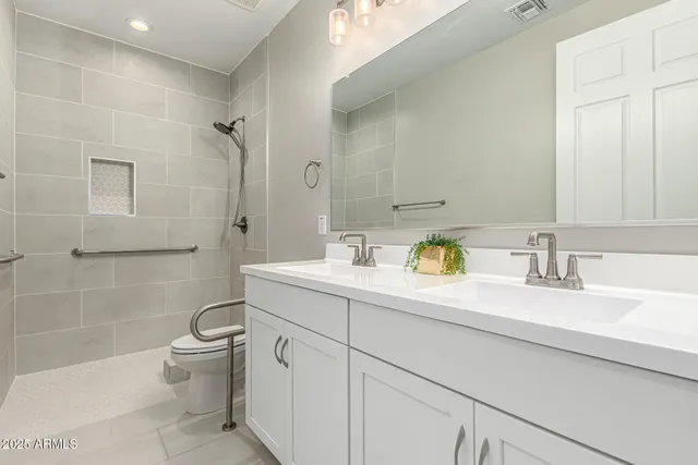 a bathroom with a granite countertop sink mirror vanity and toilet