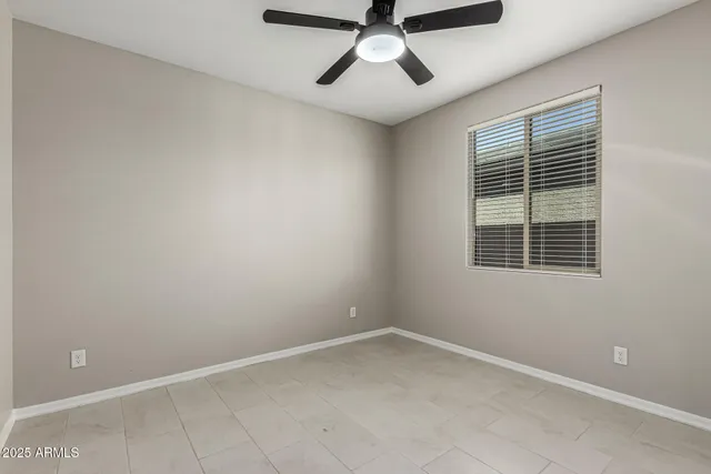 an empty room with a window and a fan