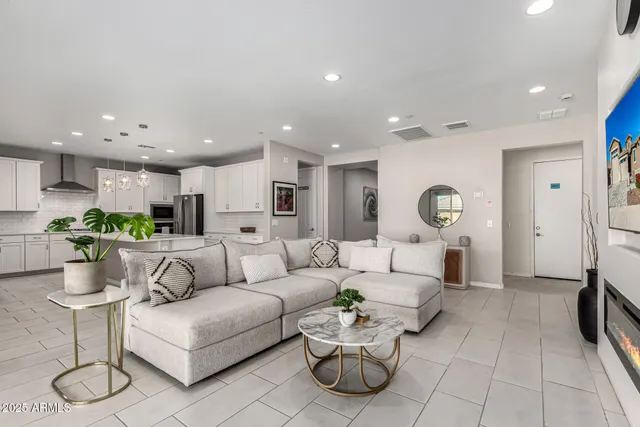a living room with furniture kitchen view and a table