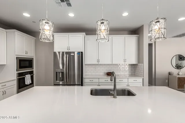 a kitchen with stainless steel appliances a refrigerator a sink and a stove