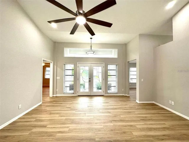 a view of an empty room with window and a kitchen