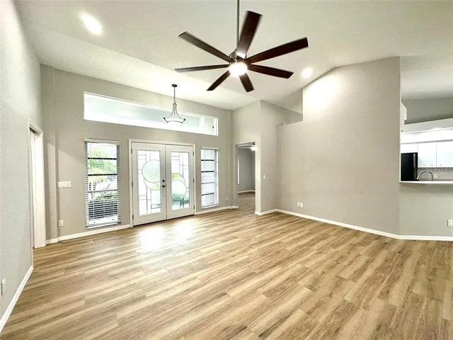 a view of an empty room with window and wooden floor