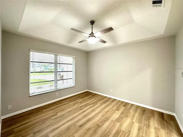 an empty room with a window and a ceiling fan