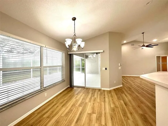 a view of a room with wooden floor and large windows