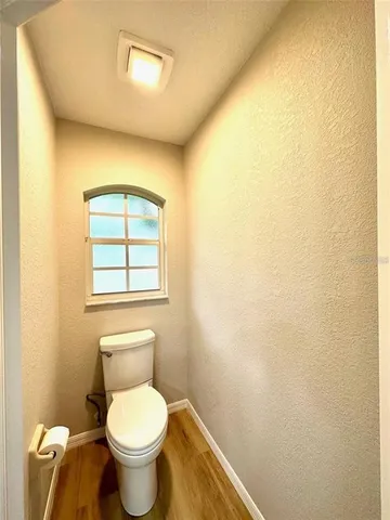 a white toilet sitting next to a white wall