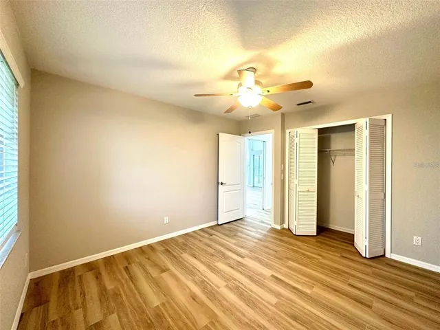 a view of a room with a ceiling fan and window