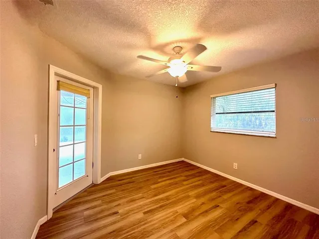 a view of a room with wooden floor and fan
