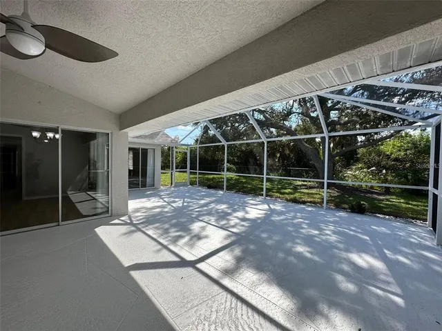 a view of an empty room with wooden floor and windows