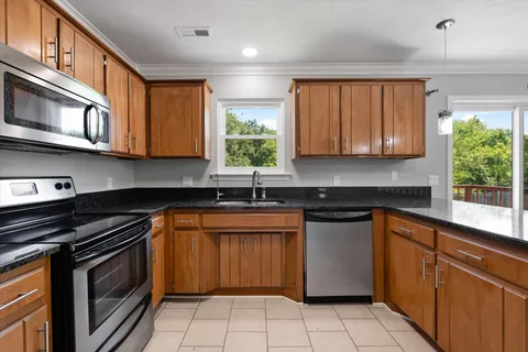 a kitchen with stainless steel appliances granite countertop a stove sink and cabinets