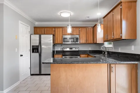 a kitchen with granite countertop a refrigerator and a sink