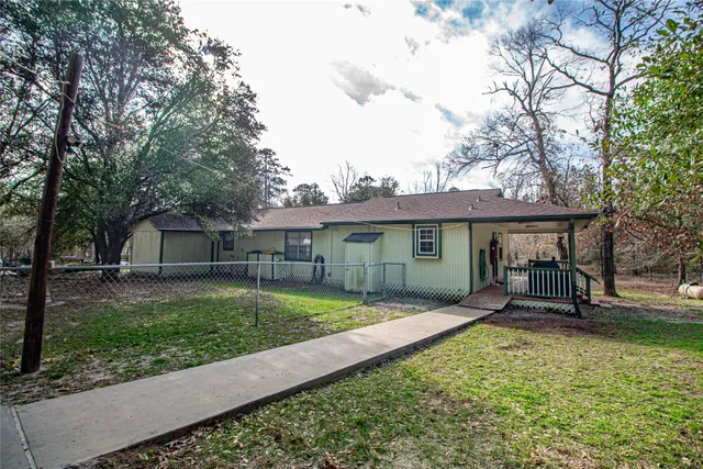a view of a house with a yard and large tree