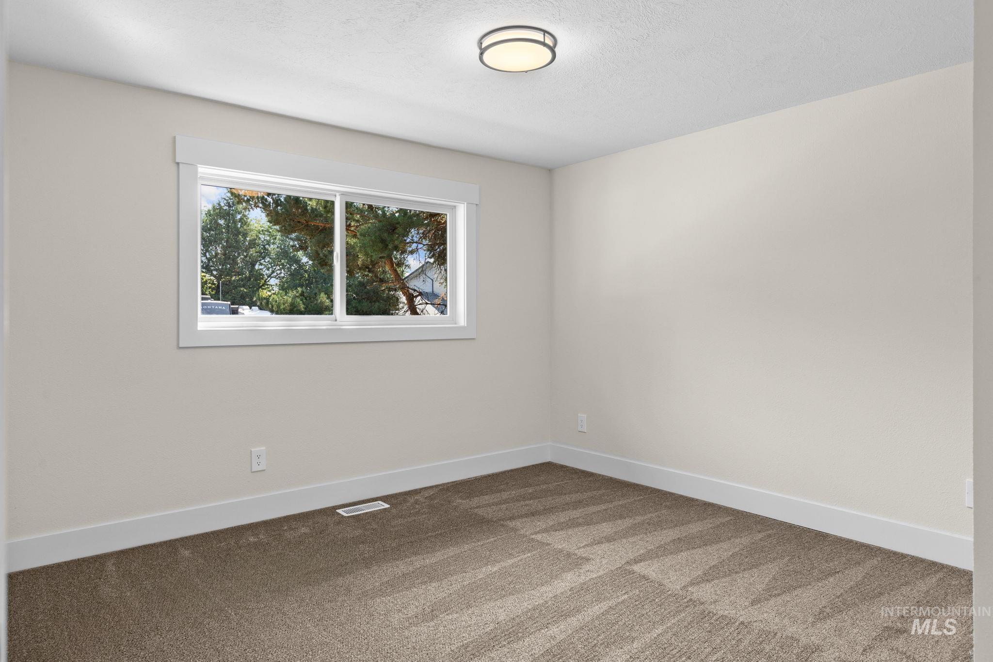 1675 Country Terrace Way Meridian, ID 83642 - Photo 20 of 50 Neutral wall tones, recessed window with white trim, flush-mount ceiling light fixture, and patterned carpet flooring
