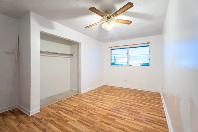 a view of a room with wooden floor and a ceiling fan