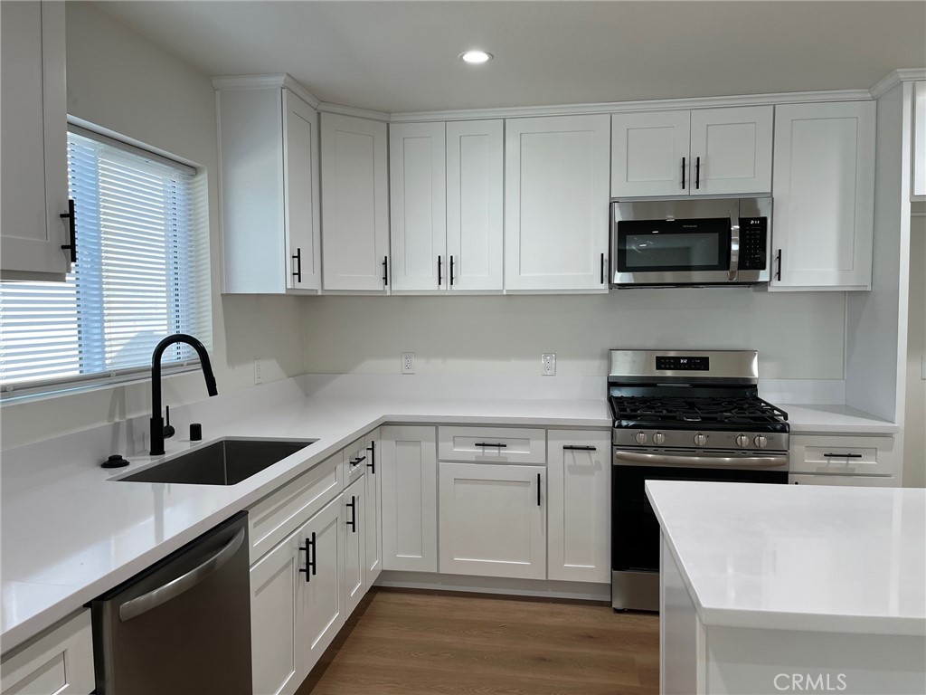 504 East Stuart Avenue, Unit 2 Redlands, CA 92374 - Photo 4 of 22 a kitchen with white cabinets and stainless steel appliances