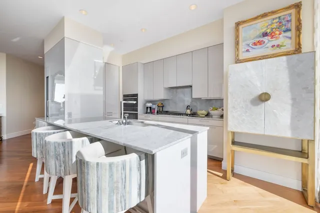 a kitchen with granite countertop a table chairs sink and cabinets
