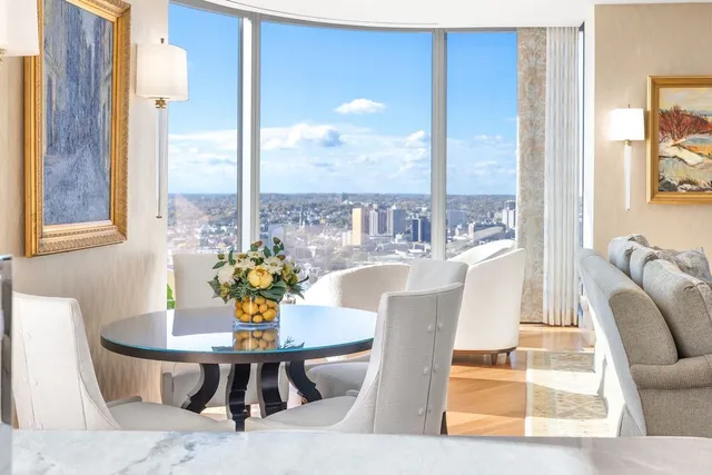 a view of a dining room with furniture a potted plant and wooden floor