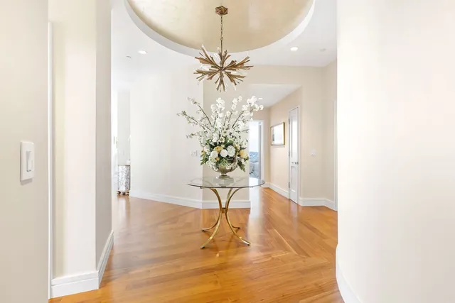 a view of a room with a chandelier and wooden floor