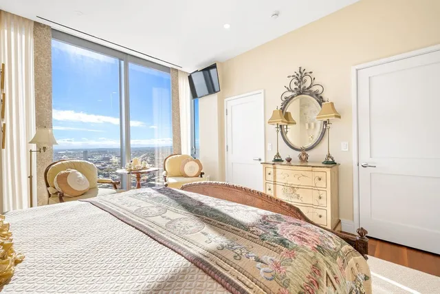 a bedroom with a bed a mirror and window