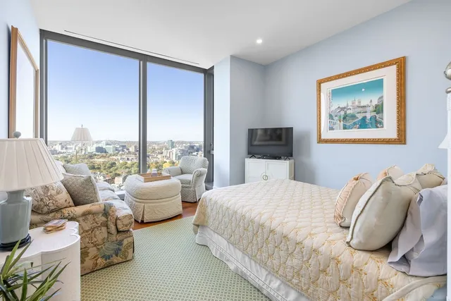 a bedroom with a bed and large windows