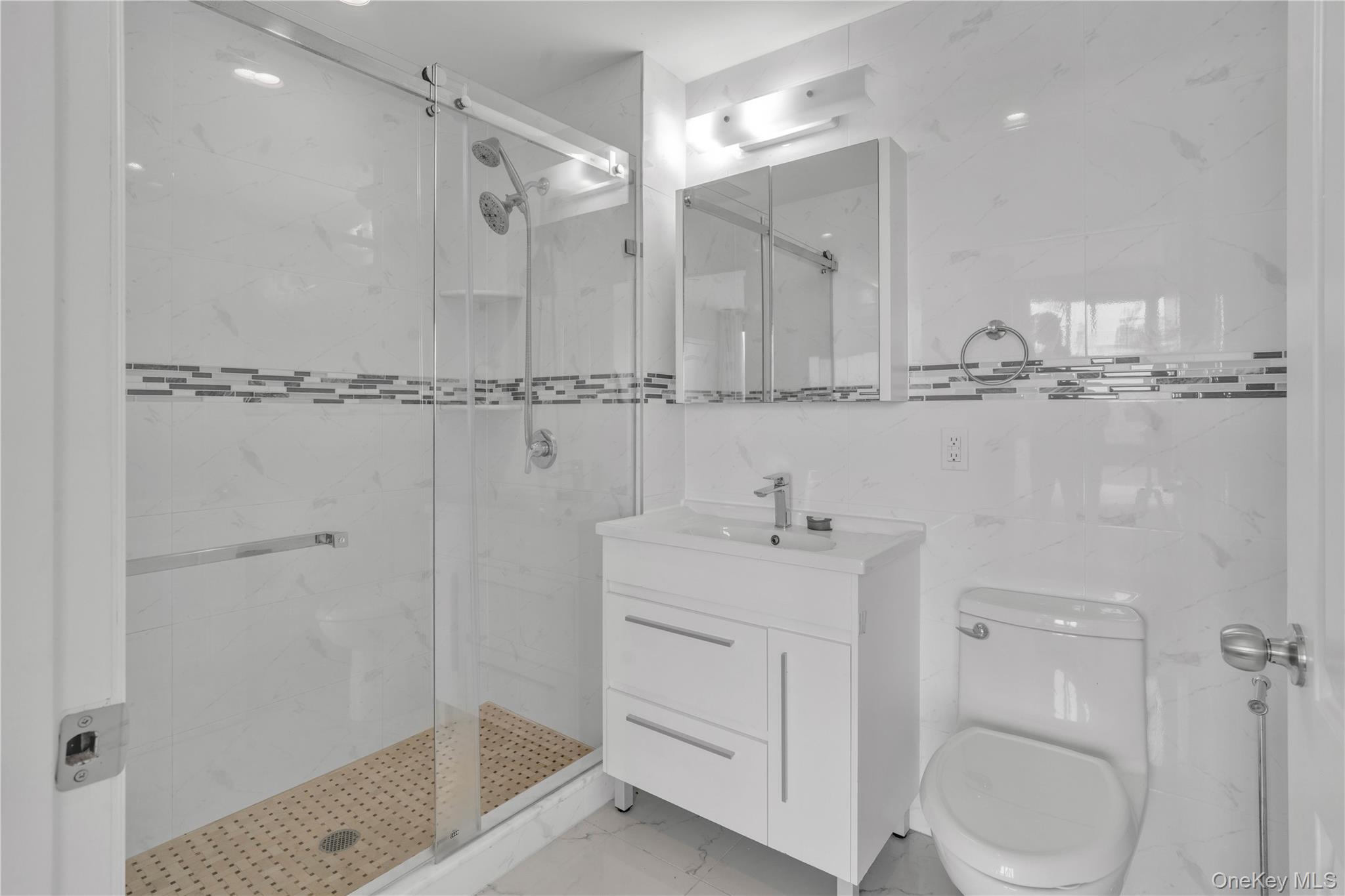 45-16 83rd Street, Unit E8F Queens, NY 11373 - Photo 11 of 19 a bathroom with a shower a sink and mirror