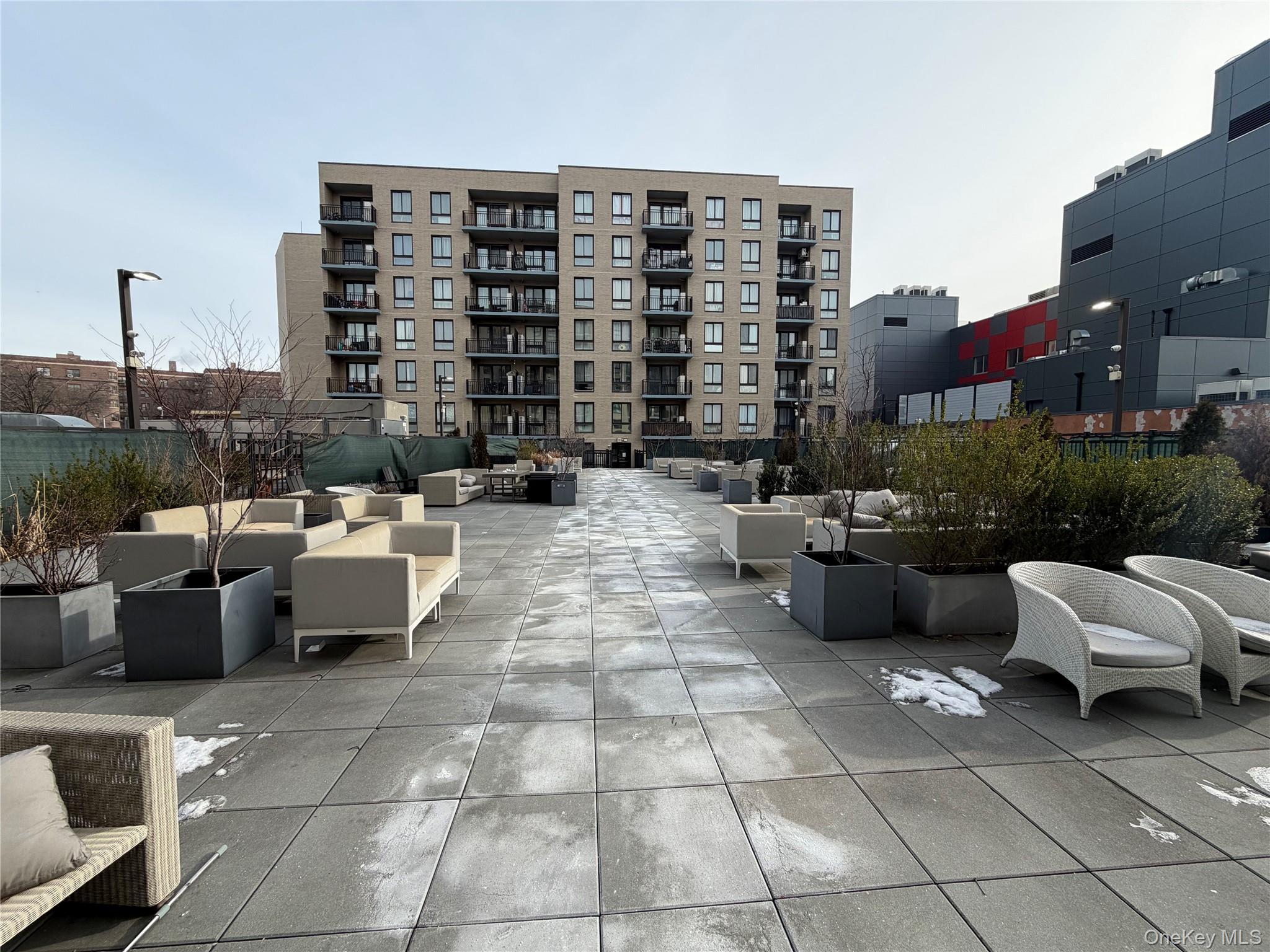 45-16 83rd Street, Unit E8F Queens, NY 11373 - Photo 18 of 19 a roof deck with couches and potted plants