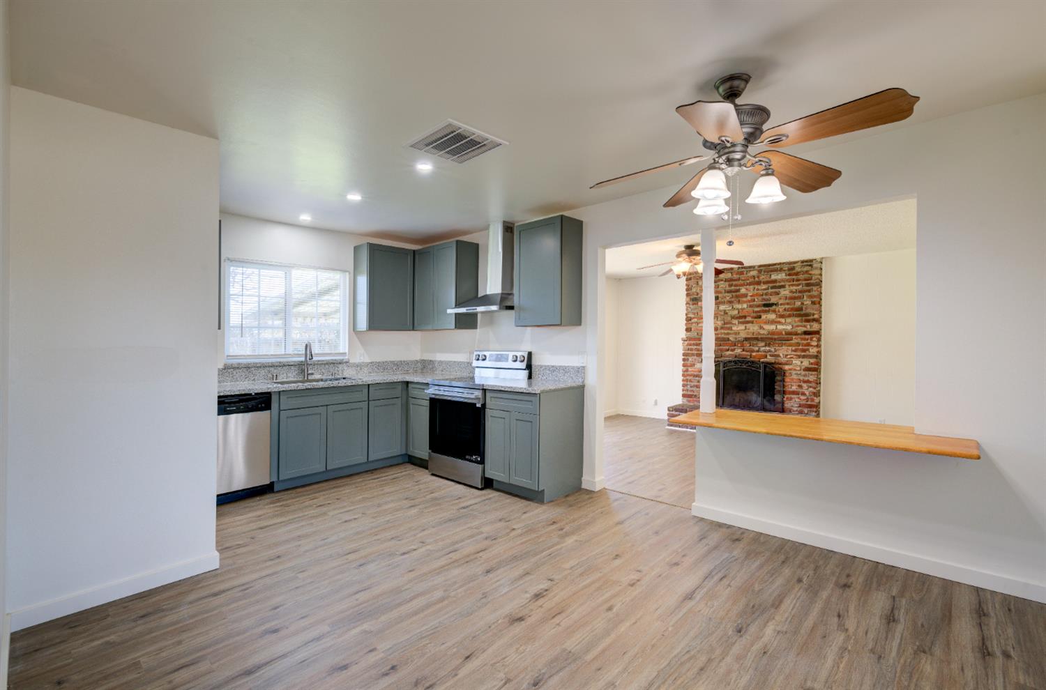 4722 North Callisch Street Fresno, CA 93726 - Photo 11 of 37 a large kitchen with a wooden floor and stainless steel appliances