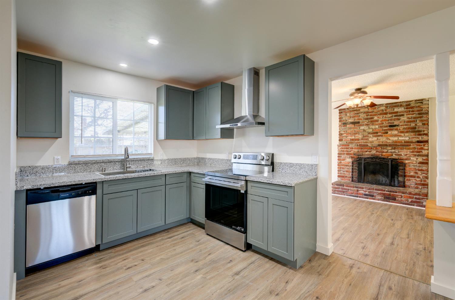 4722 North Callisch Street Fresno, CA 93726 - Photo 12 of 37 a kitchen with stainless steel appliances granite countertop a stove a sink and a microwave