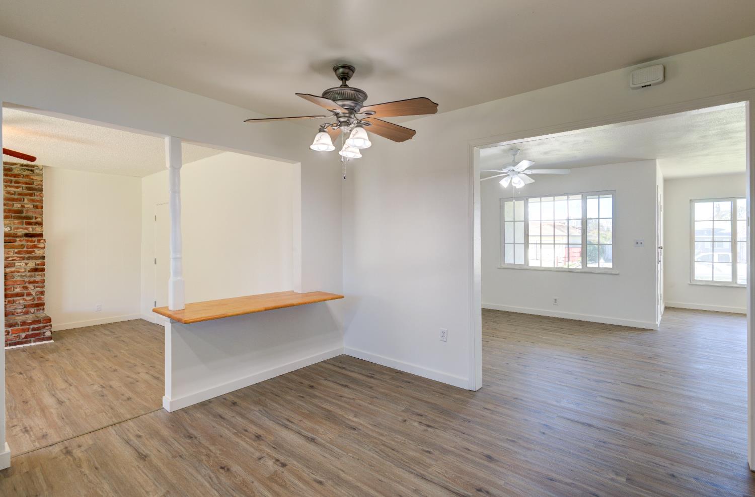 4722 North Callisch Street Fresno, CA 93726 - Photo 15 of 37 an empty room with wooden floor chandelier fan and windows