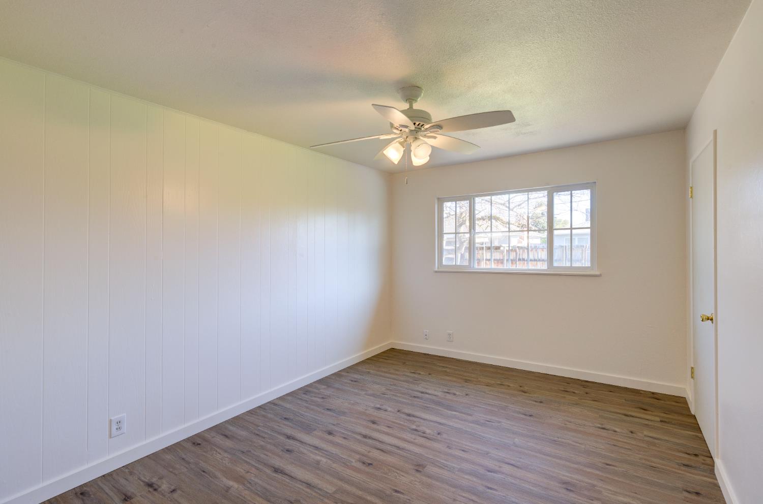 4722 North Callisch Street Fresno, CA 93726 - Photo 22 of 37 an empty room with wooden floor fan and windows