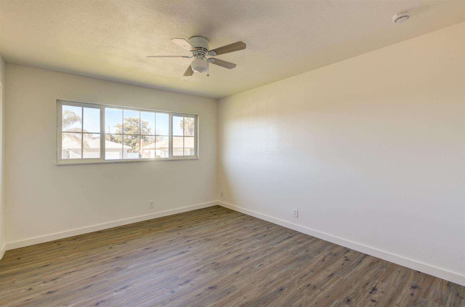 4722 North Callisch Street Fresno, CA 93726 - Photo 26 of 37 a view of an empty room with wooden floor and a window