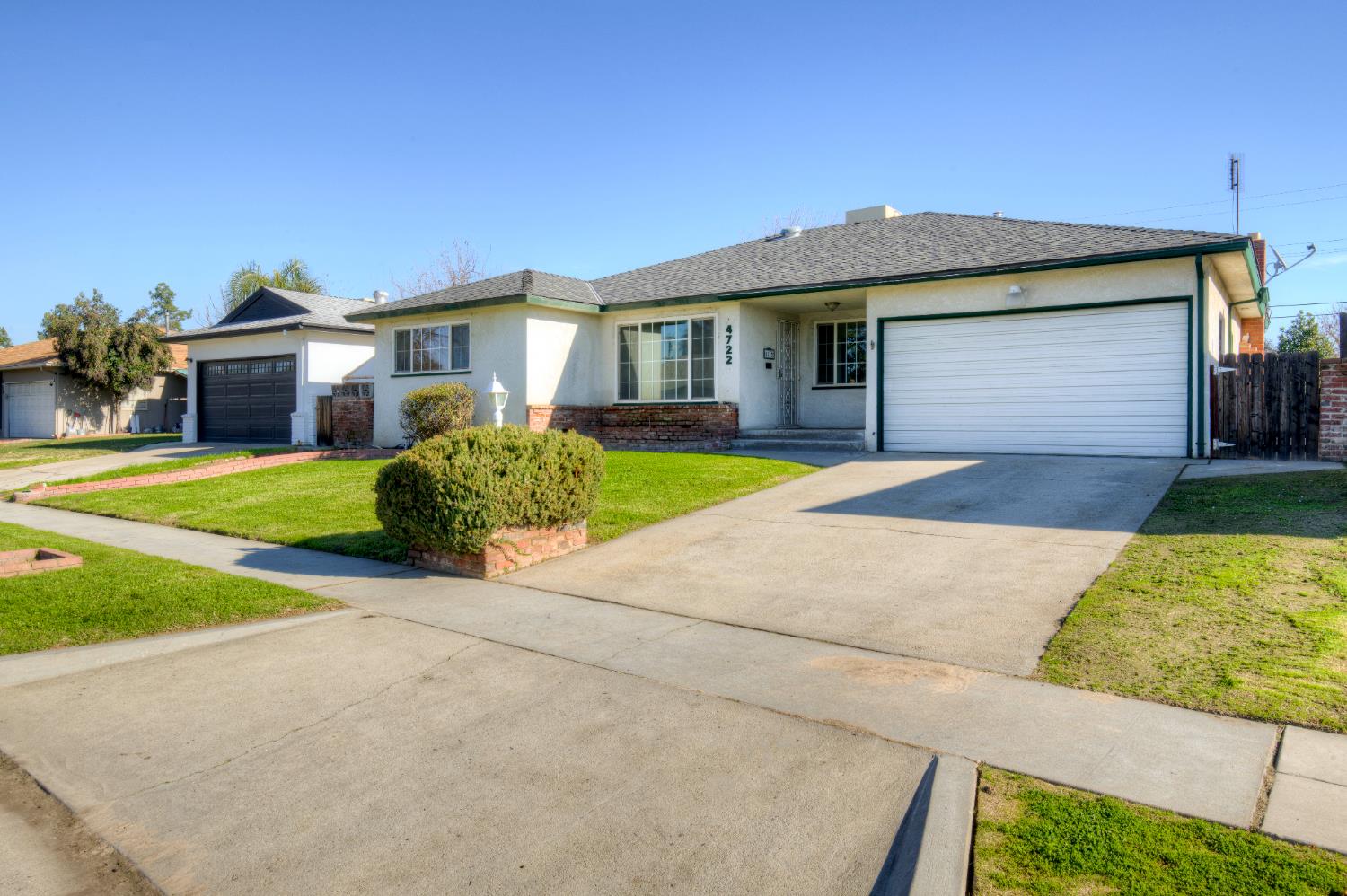 4722 North Callisch Street Fresno, CA 93726 - Photo 4 of 37 a front view of a house with a yard and garage