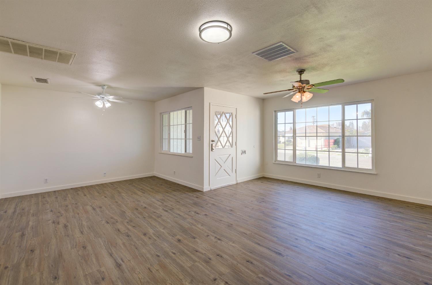 4722 North Callisch Street Fresno, CA 93726 - Photo 6 of 37 an empty room with wooden floor and windows