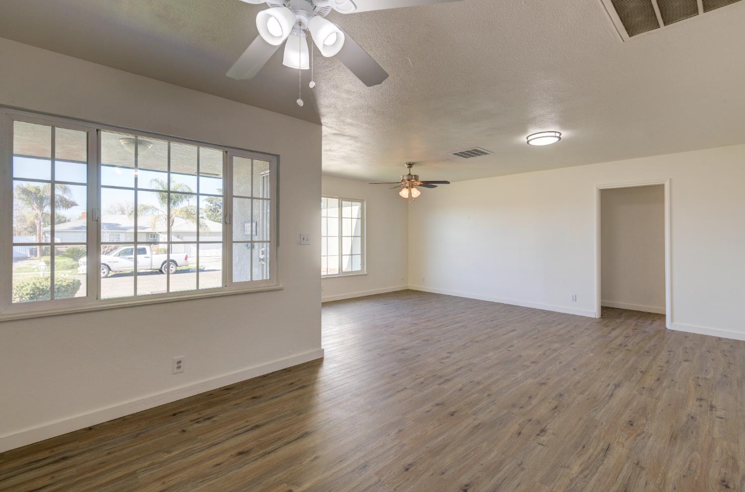 4722 North Callisch Street Fresno, CA 93726 - Photo 8 of 37 an empty room with wooden floor and windows