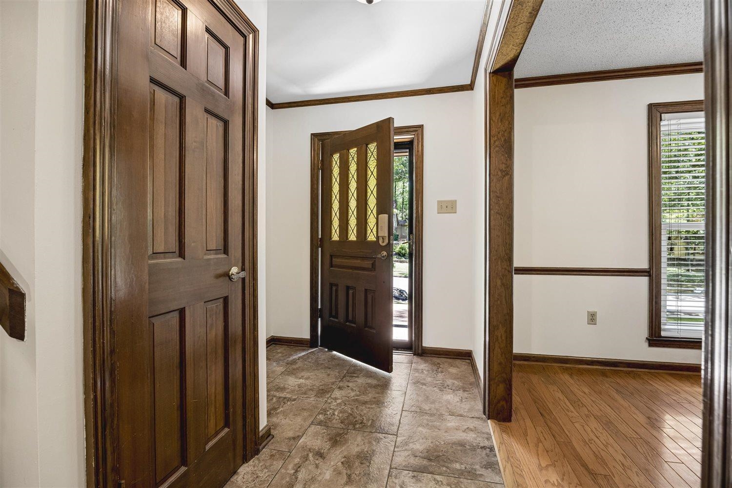 8970 Farmoor Road Germantown, TN 38139 - Photo 4 of 35 Entryway featuring a wood-panel door with decorative glass inserts, ceramic tile flooring, and wood trim accents