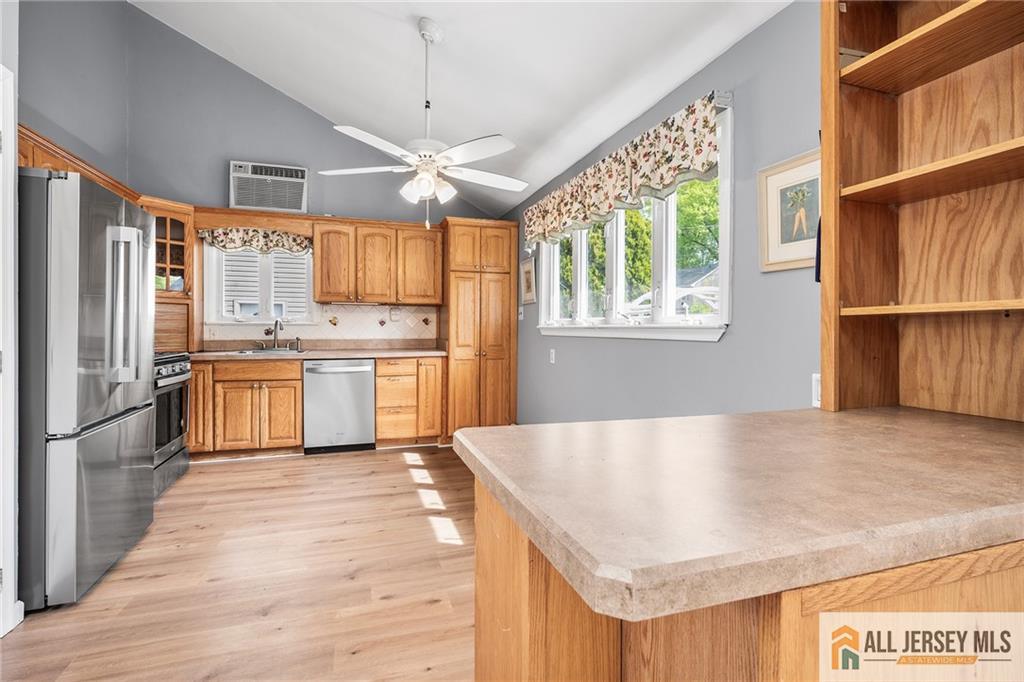 67 Drake Place Colonia, NJ 07067 - Photo 7 of 31 a kitchen with stainless steel appliances granite countertop a refrigerator a sink dishwasher a stove and white countertops with wooden floor