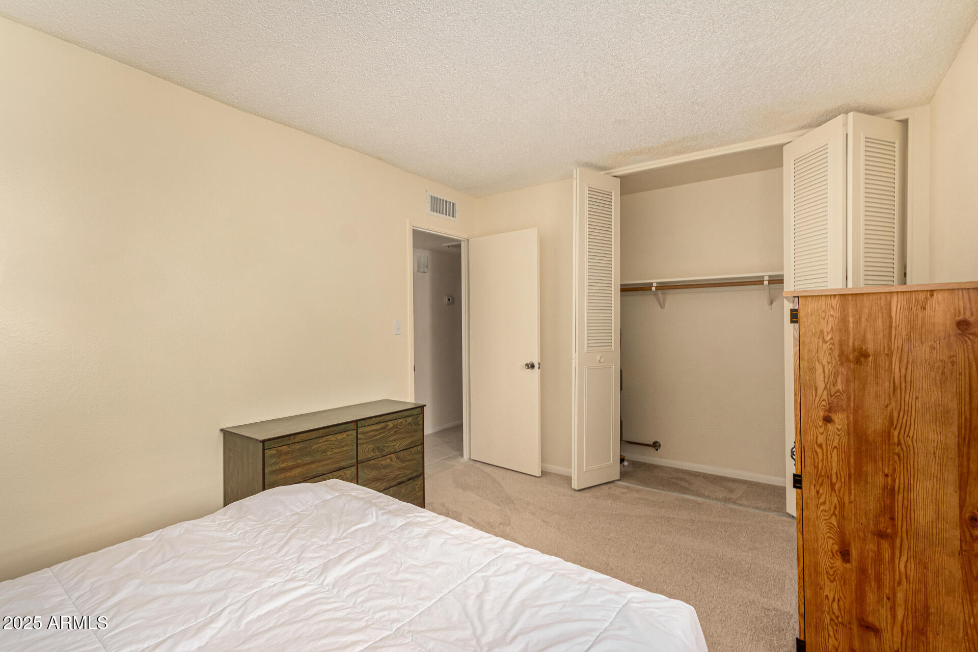 641 South Power Road, Unit 364 Mesa, AZ 85206 - Photo 22 of 32 a bedroom with a bed and a cabinet