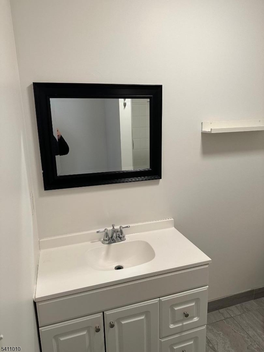 471 Pompton Avenue, Unit 3 Cedar Grove, NJ 07009 - Photo 3 of 7 a bathroom with a sink and a mirror