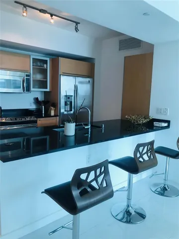 a kitchen with a sink a stove and chairs