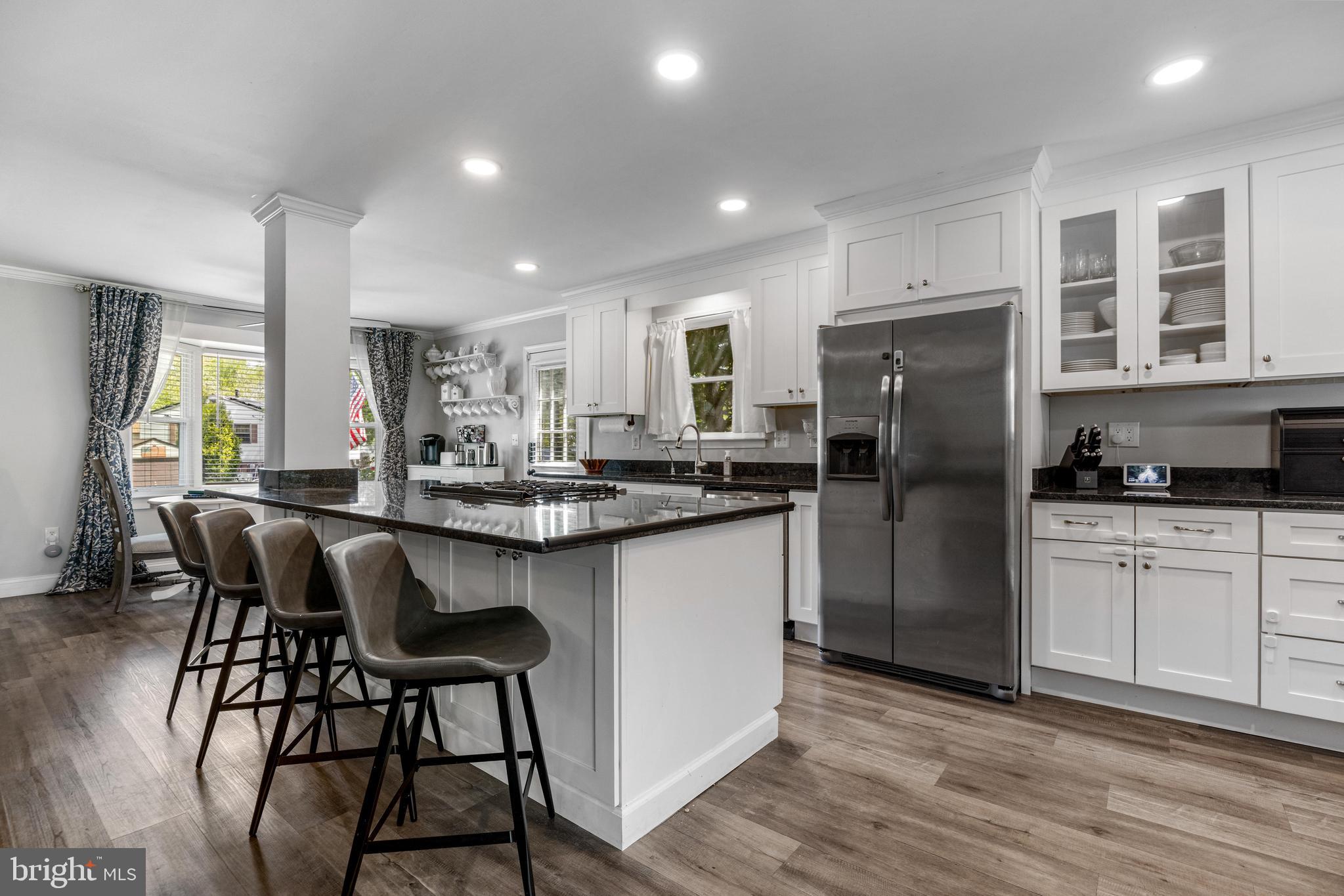 3006 Bass Place Riva, MD 21140 - Photo 11 of 51 a kitchen with stainless steel appliances granite countertop a refrigerator a stove a sink and a dining table with wooden floor