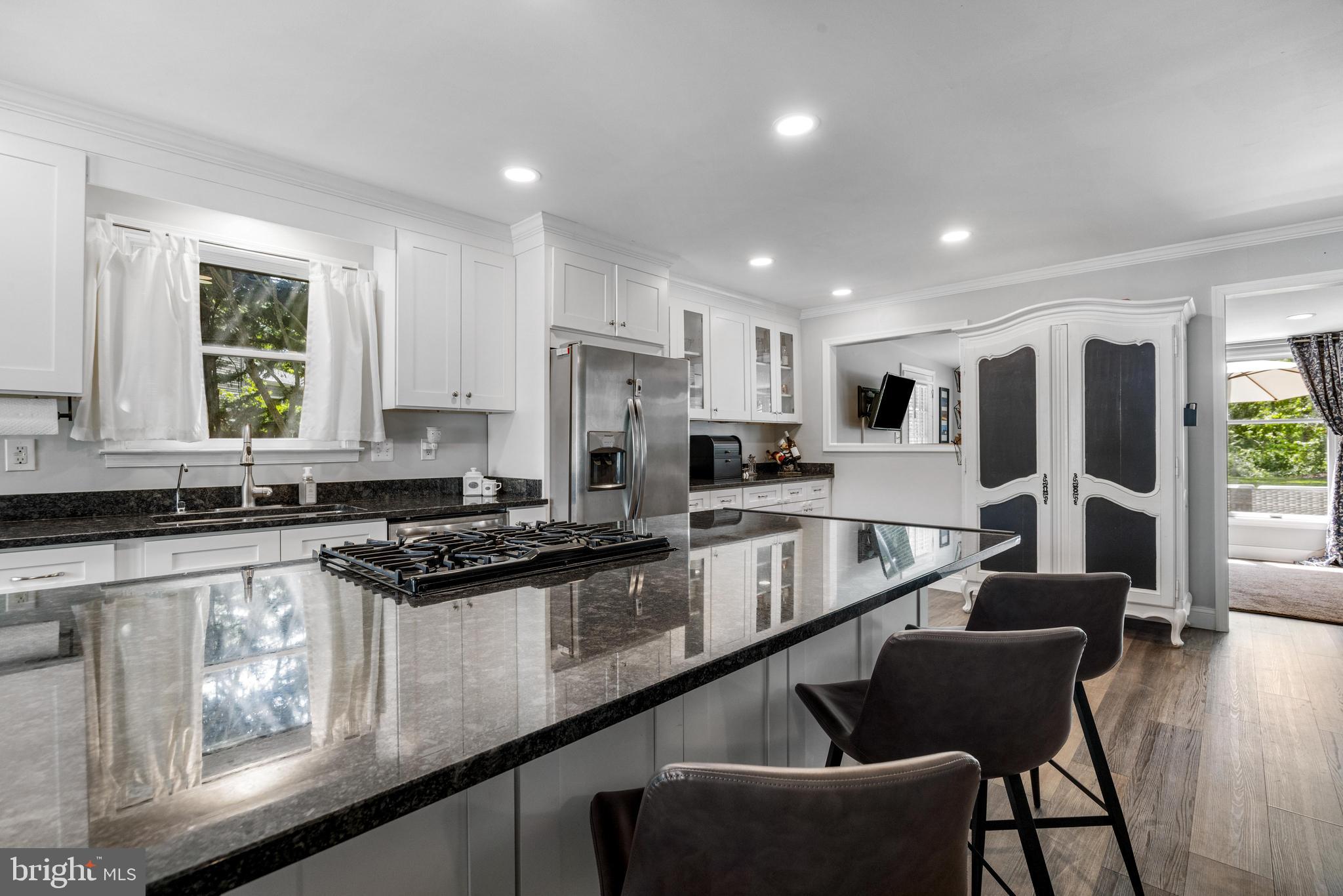3006 Bass Place Riva, MD 21140 - Photo 12 of 51 a large kitchen with stainless steel appliances granite countertop a stove a sink a refrigerator and white cabinets with wooden floor