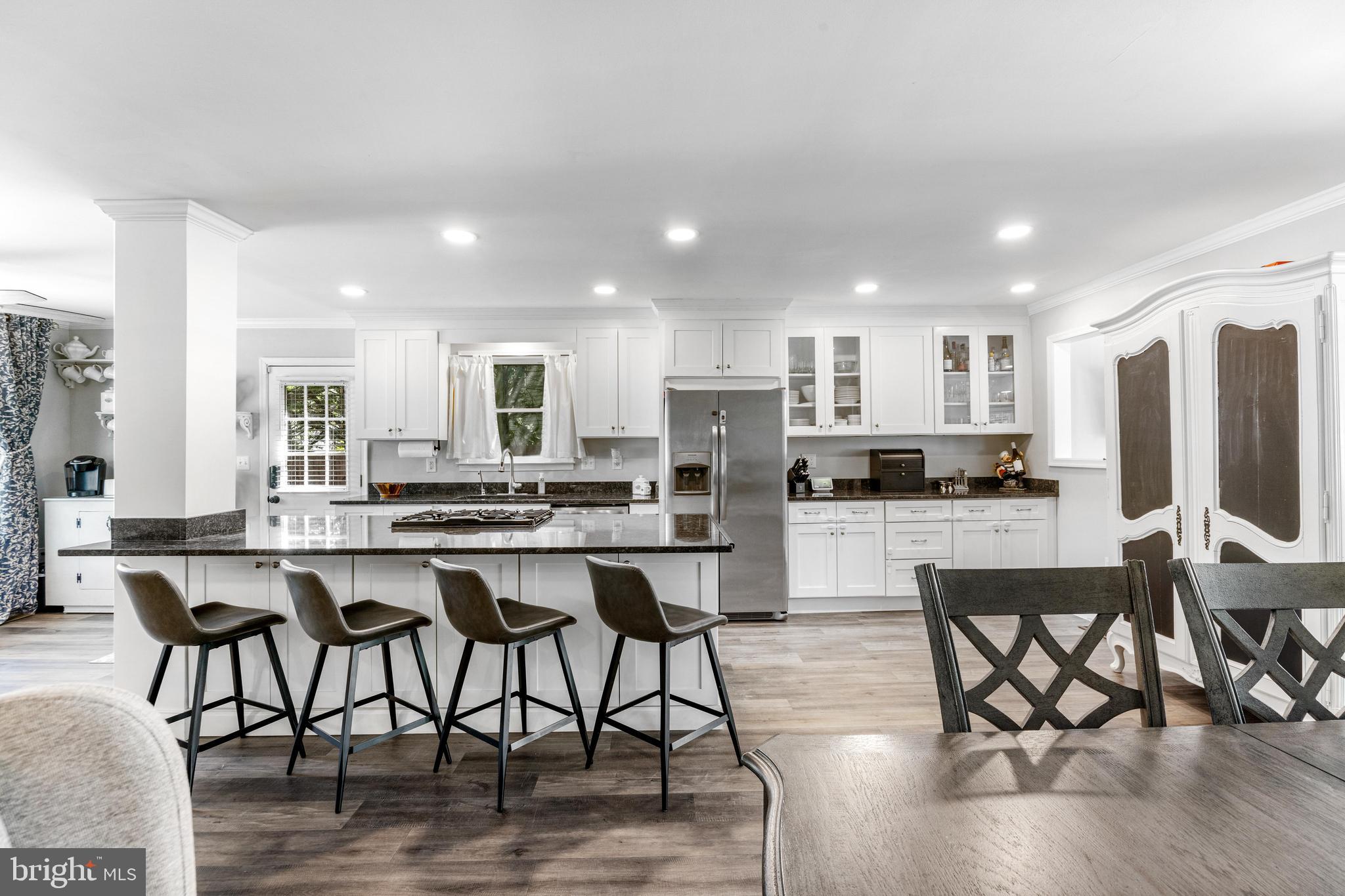 3006 Bass Place Riva, MD 21140 - Photo 13 of 51 a kitchen with stainless steel appliances kitchen island granite countertop a dining table chairs and granite counter tops