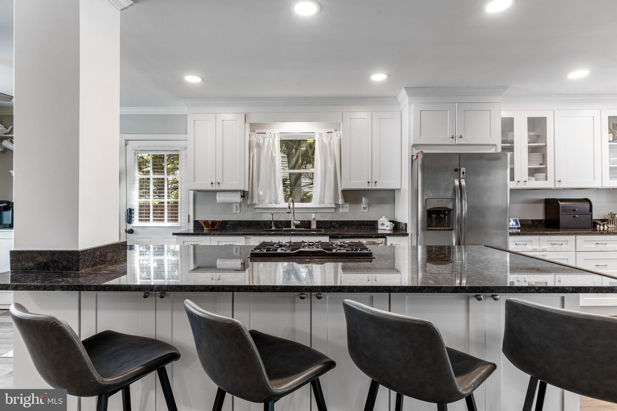 3006 Bass Place Riva, MD 21140 - Photo 10 of 51 a kitchen with stainless steel appliances granite countertop a stove top oven a refrigerator a sink and chairs