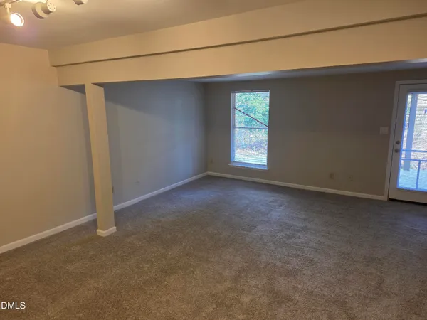 a view of a livingroom with an empty space and a window
